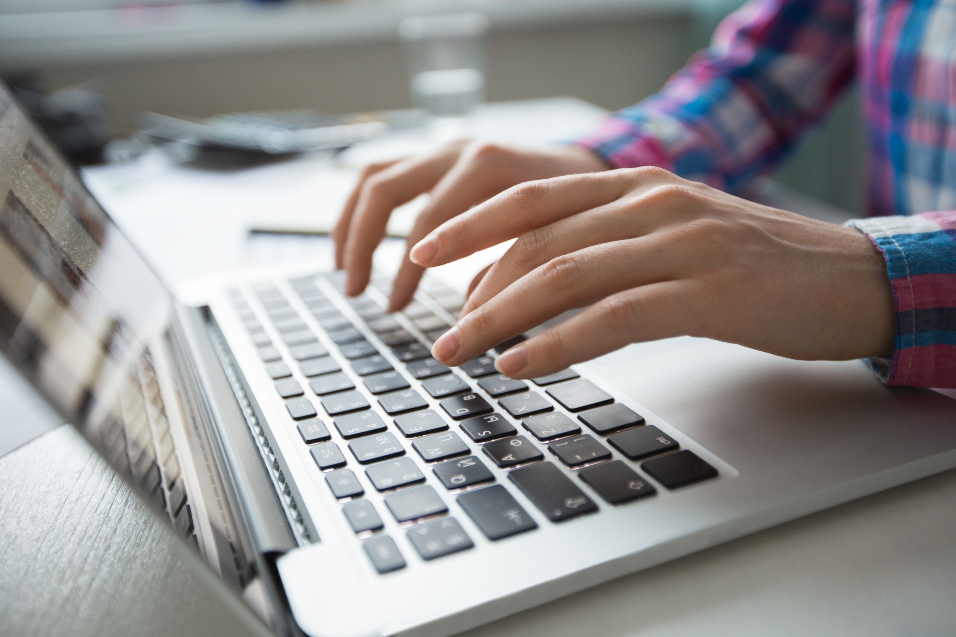 An image of a male hand while writing on his own laptop, in the office work