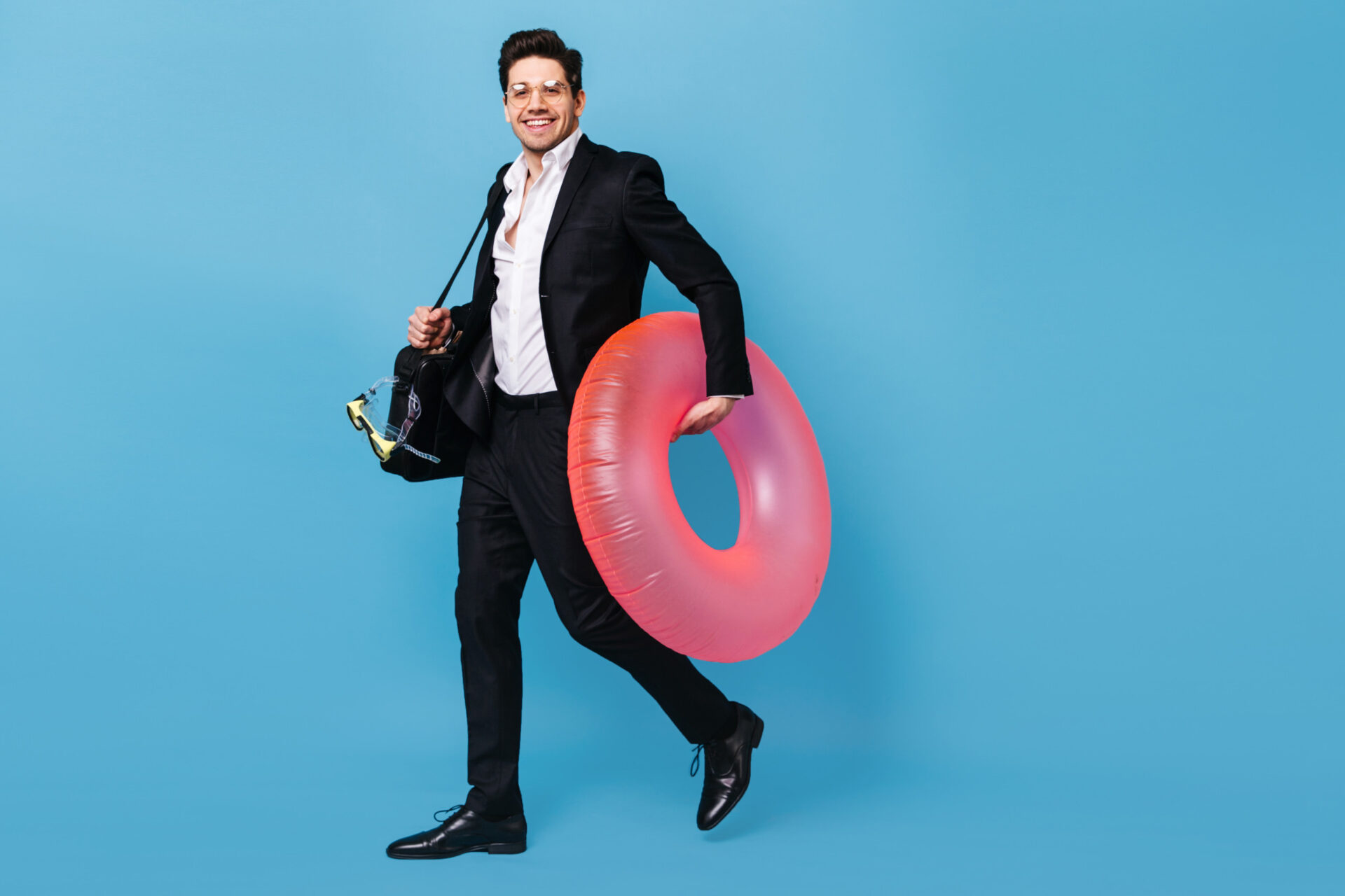 An image of an employee, wearing a suit and holding a pink float in his hands