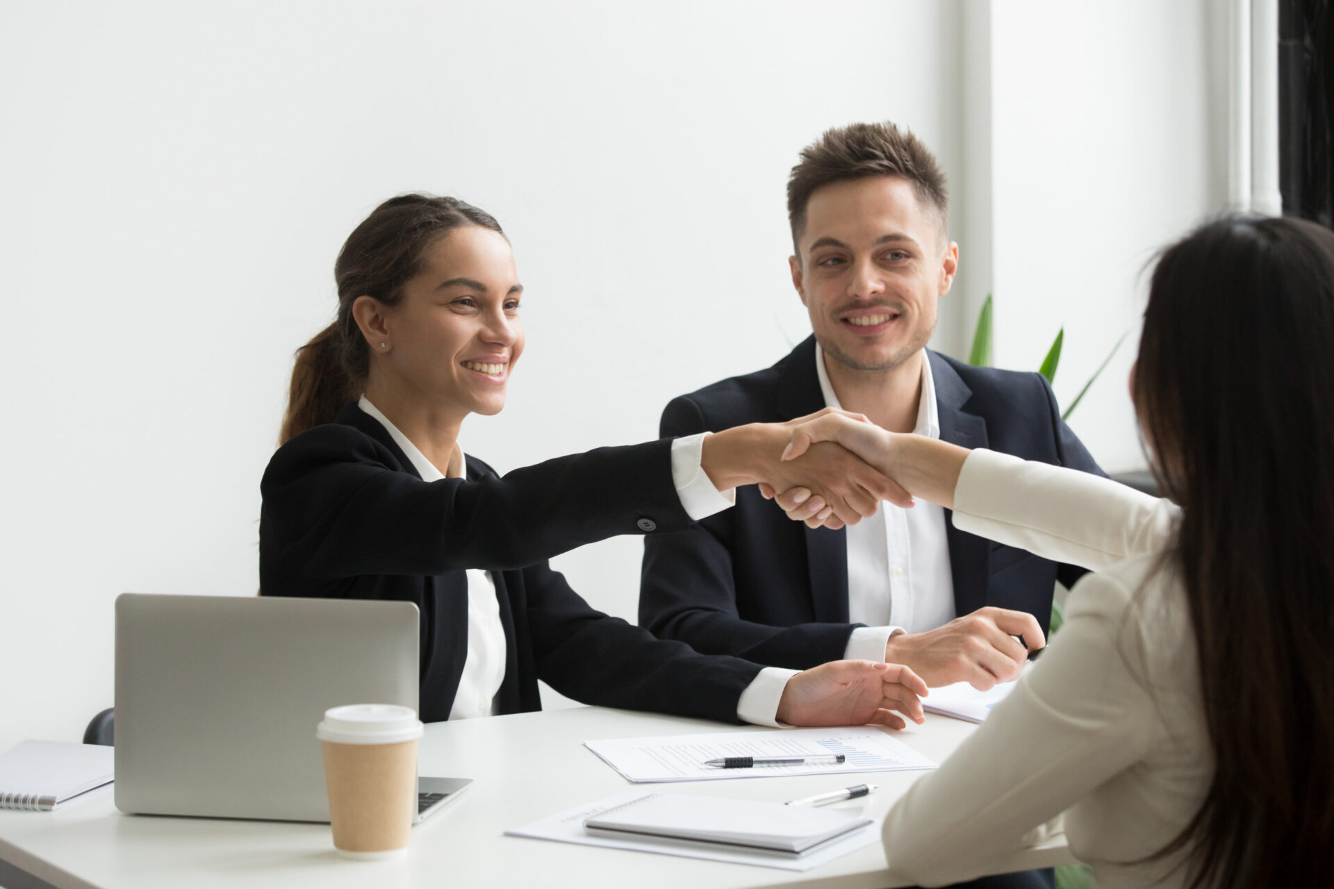 An image of two female employees shaking hands