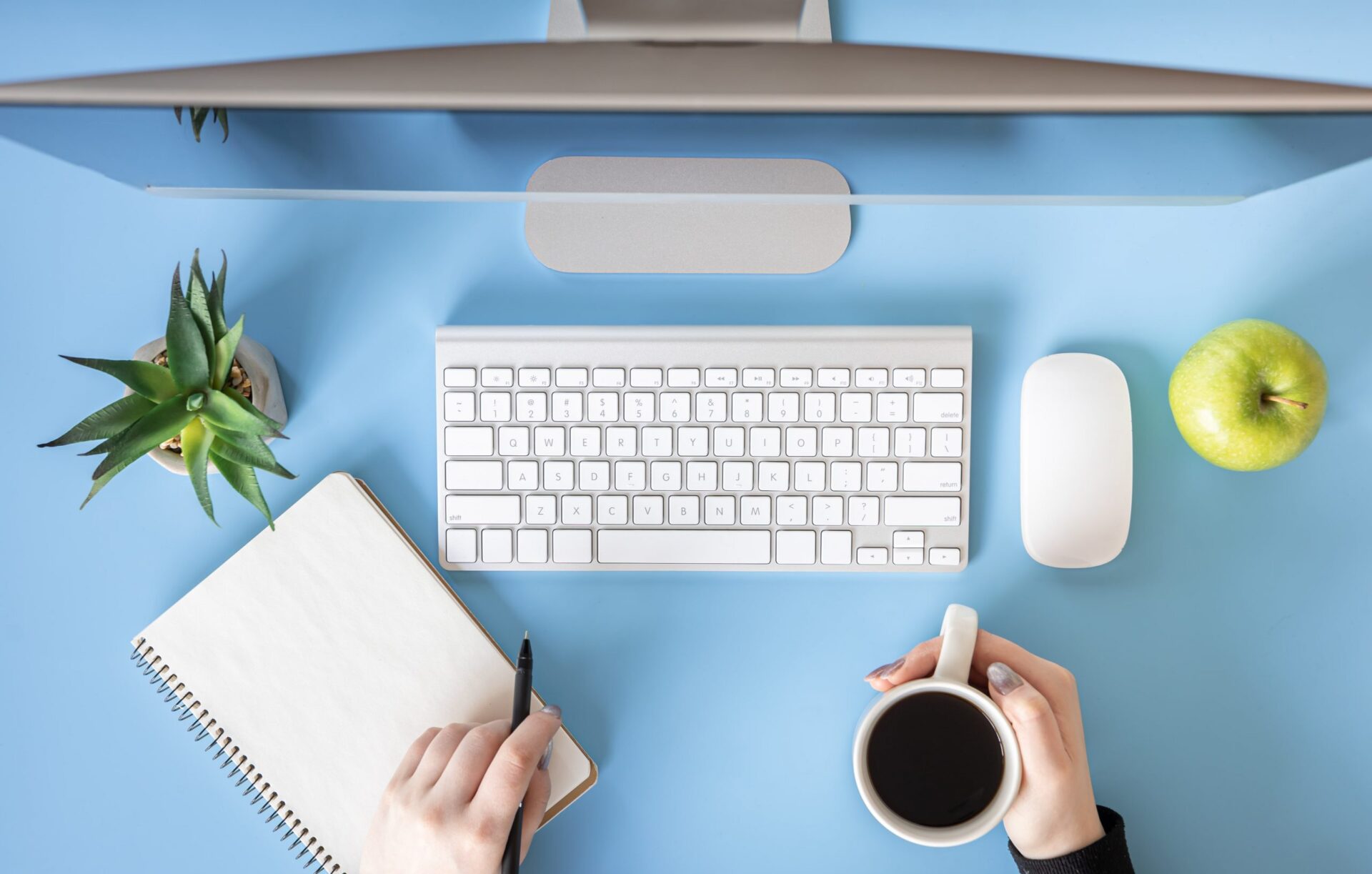 top-view-female-hands-work-computer-blue-background