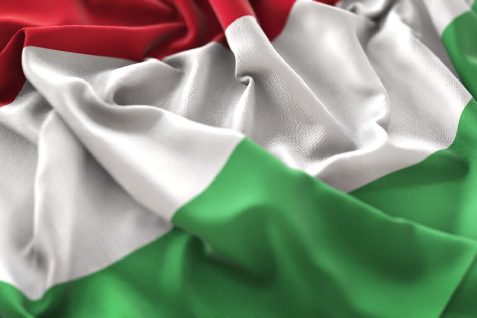 A close-up image of a fabric flag featuring horizontal stripes in three colors: red on top, white in the middle, and green on the bottom. The fabric appears soft and slightly wrinkled, creating a sense of movement and texture in the flag. The colors are vibrant and distinct, symbolizing the national identity of Hungary.
