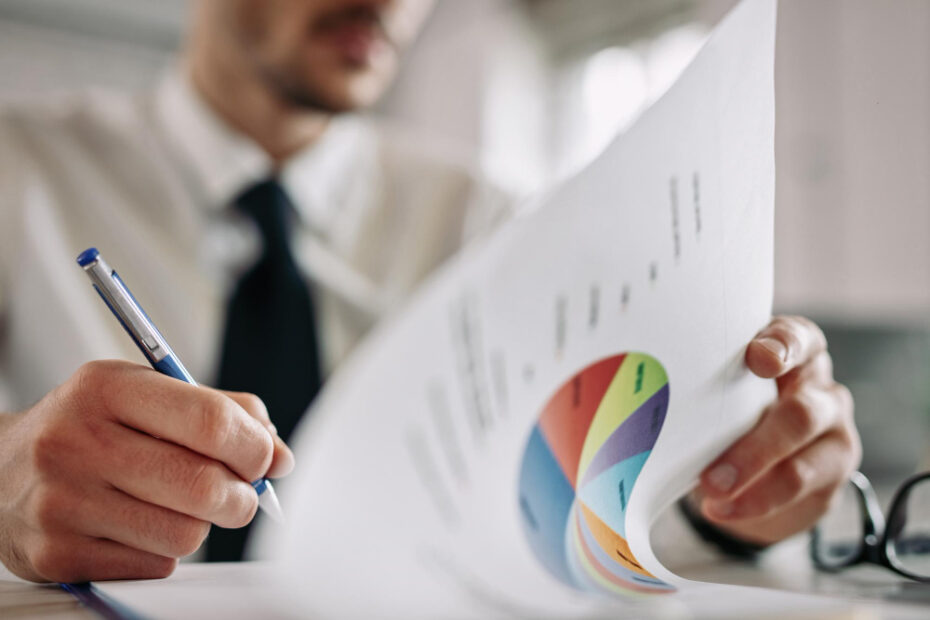 close up entrepreneur going through business reports taking notes office.