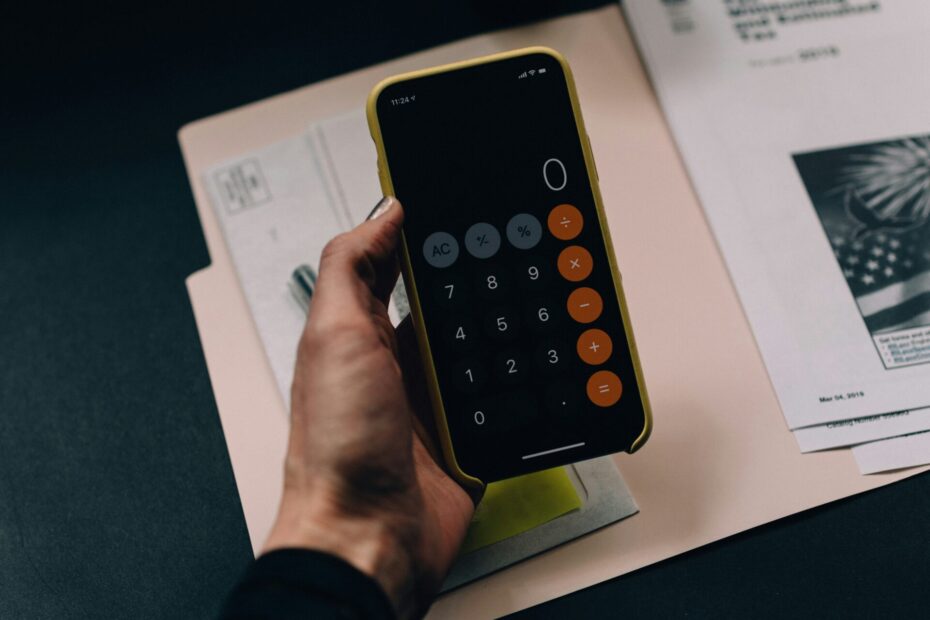 An employee holding his phone to calculate something.
