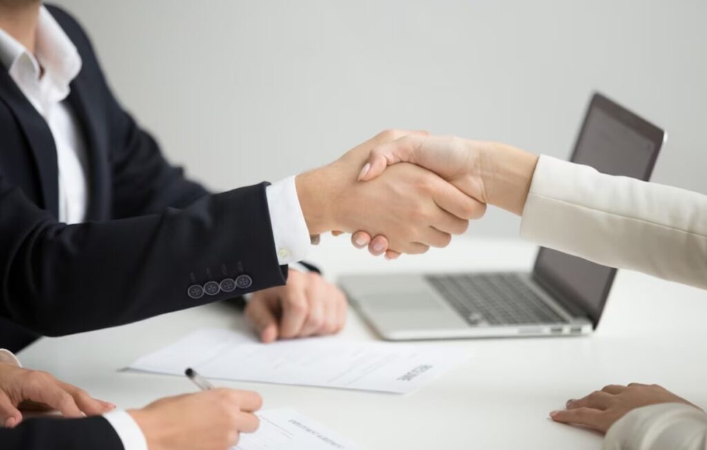 Two employees are shaking hands in the office.
